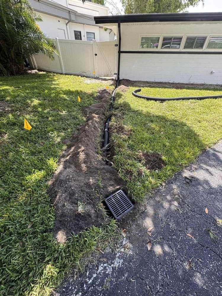 Yard drain trench with catch basin grate in front lawn